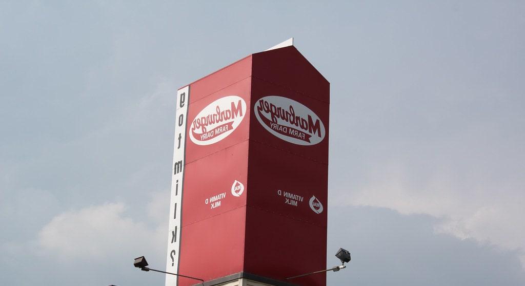 Photo of a large red milk carton reading "Marburger Dairy" on top of a production facility in Pennsylvania. 