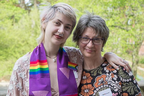Photo of a Chatham University student with a rainbow graduation stole at Lavender Graduation, accompanied by an older woman